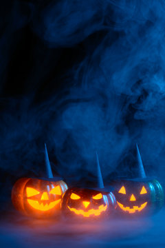 Glowing pumpkins in blue smoke