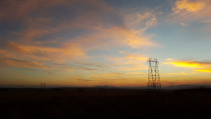 Power lines silhouetted against a sunset sky.