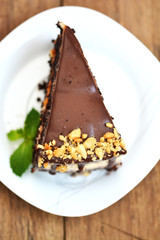 Top view of tasty chocolate cake with nuts on white plate