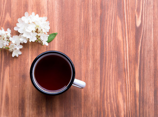 tea cup  and white flower of hydrangea on wooden table, top view