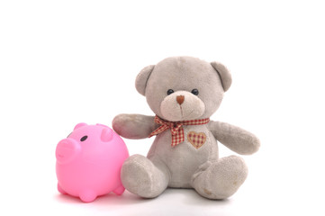 Doll bear with plastic piggy bank, money saving conceptual.