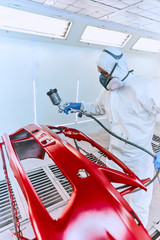 Painting bumpers machine red in the paint shop.