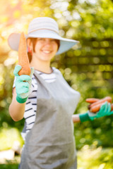 Brunette in hat holding carrot