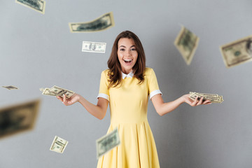 Happy young caucasian lady standing over levitate money