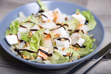 Salad with feta cheese, melons and cedar nuts. Selective focus.