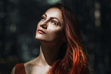 Portrait of a beautiful red-haired girl on a background of nature