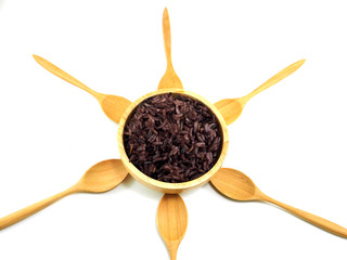 Rice berry in wooden bowl with spoon around