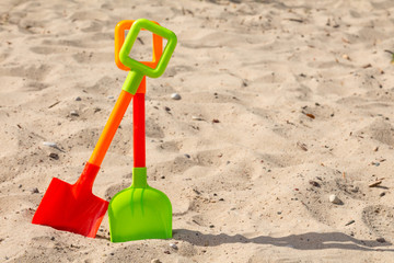 Fototapeta na wymiar Pastic shovels on the beach sand