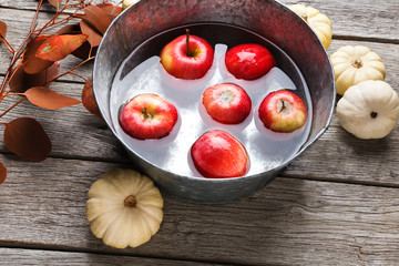 Metal basin with apples in water. Autumn harvest background