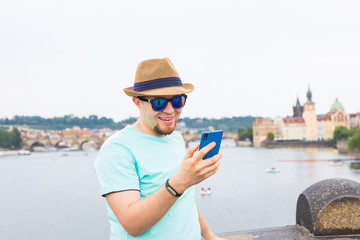 Young hipster man using mobile smart phone outdoor
