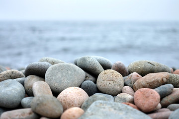 Fototapeta na wymiar Round sea stones in front of water