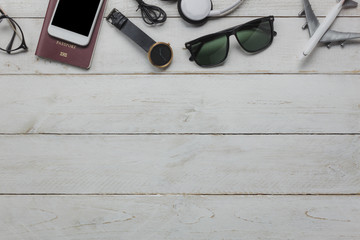 Top view of accessories essential to travel and technology background concept. Several of items for teenage or adult for traveler. Mix variety the objects on modern rustic white wooden office desk.   