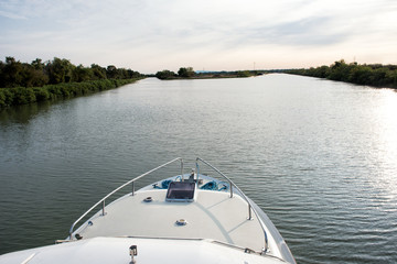 Fototapeta na wymiar Cruise boat approaching a fork in a canal