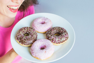 Close-up of woman holding plate with delicious sweet donuts