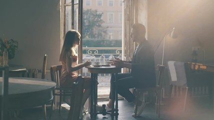 Couple lovers talking in cafe for a cup coffee. Man and woman sitting in a cafe