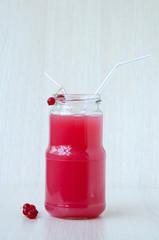 On beige background, a red currant drink