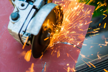 metal sawing close up -  with angle grinder. Sparks while grinding iron