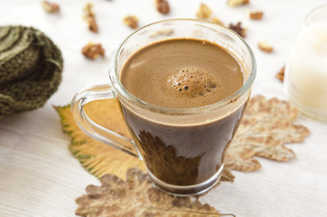 Hot coffee on rustic table with leaves. Autumn time.