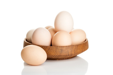 chicken eggs in a wooden plate isolated on white background