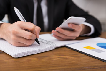 Man taking notes at workplace, top view