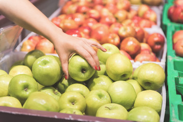 Woman arm keeping fresh apple