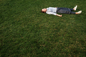 Fototapeta na wymiar Beautiful young european woman lays down on grass and rests