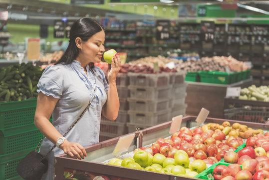 Cheerful lady choosing fresh fruit