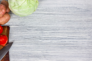 Assorted fresh vegetables with knife white wooden background Top view point.
