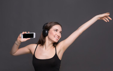 Woman listen to music in earphones, studio shot