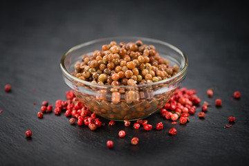 Preserved Pink Peppercorns on a slate slab, selective focus