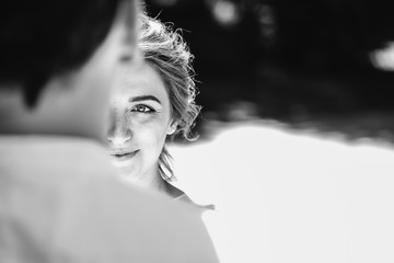 Beautiful bride in her wedding day looking at groom, fear and uncertainty in her eyes. outdoors....