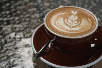 Hot coffee latte with beautiful latte art  on ceramic glass in local indy coffee cafe at Thailand.