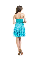 Fototapeta premium Back view of young beautiful woman in turquoise cocktail dress