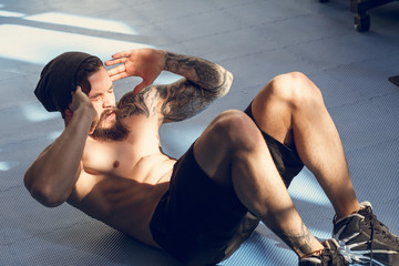 Muscular man exercising doing sit up exercise. Athlete with six pack, white male, no shirt