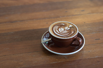 Hot coffee mocha with beautiful latte art topping with choccolate powder on ceramic glass.