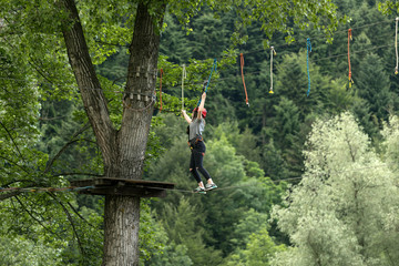 Girl climbing in adventure park, rope park 
