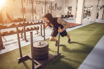 Fitness sled push man pushing weights workout exercise