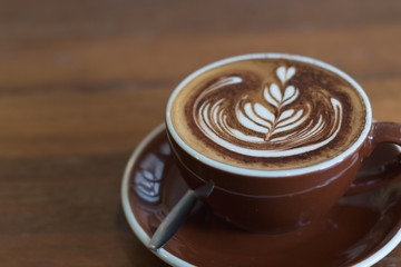 Hot coffee mocha with beautiful latte art topping with choccolate powder on ceramic glass.