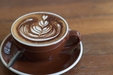 Hot coffee mocha with beautiful latte art topping with choccolate powder on ceramic glass.