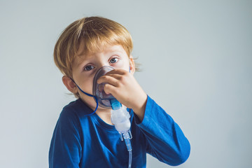 Boy making inhalation with a nebulizer at home