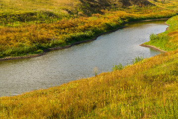 The pond is surrounded by autumn steppe grass. Russia, Lipetsk region.