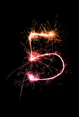 "5" number drawn with bengali sparkles isolated on black background,number from sparkler on black background