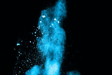 Abstract blue powder splatted on white background. Freeze motion of blue powder exploding on black...