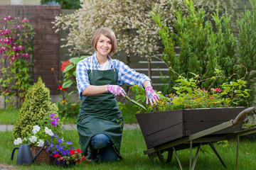 Young smiling woman florist working in the garden.