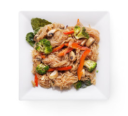 Funchoza salad with rice noodles and vegetables on white dish isolated on a white background
