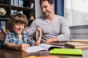 son doing homework with father