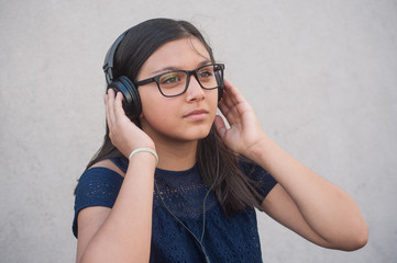 Fototapeta premium jeune adolescente avec un casque de musique en extérieur