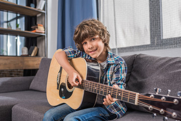 child playing acoustic guitar