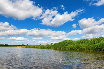 Blue cloudy summer sky over Bug river, Poland, Europe