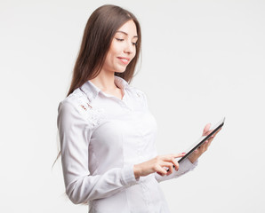 Smiling young businesswoman showing blank no-name tablet pc monitor with copyspace area for slogan or text message. business concept.